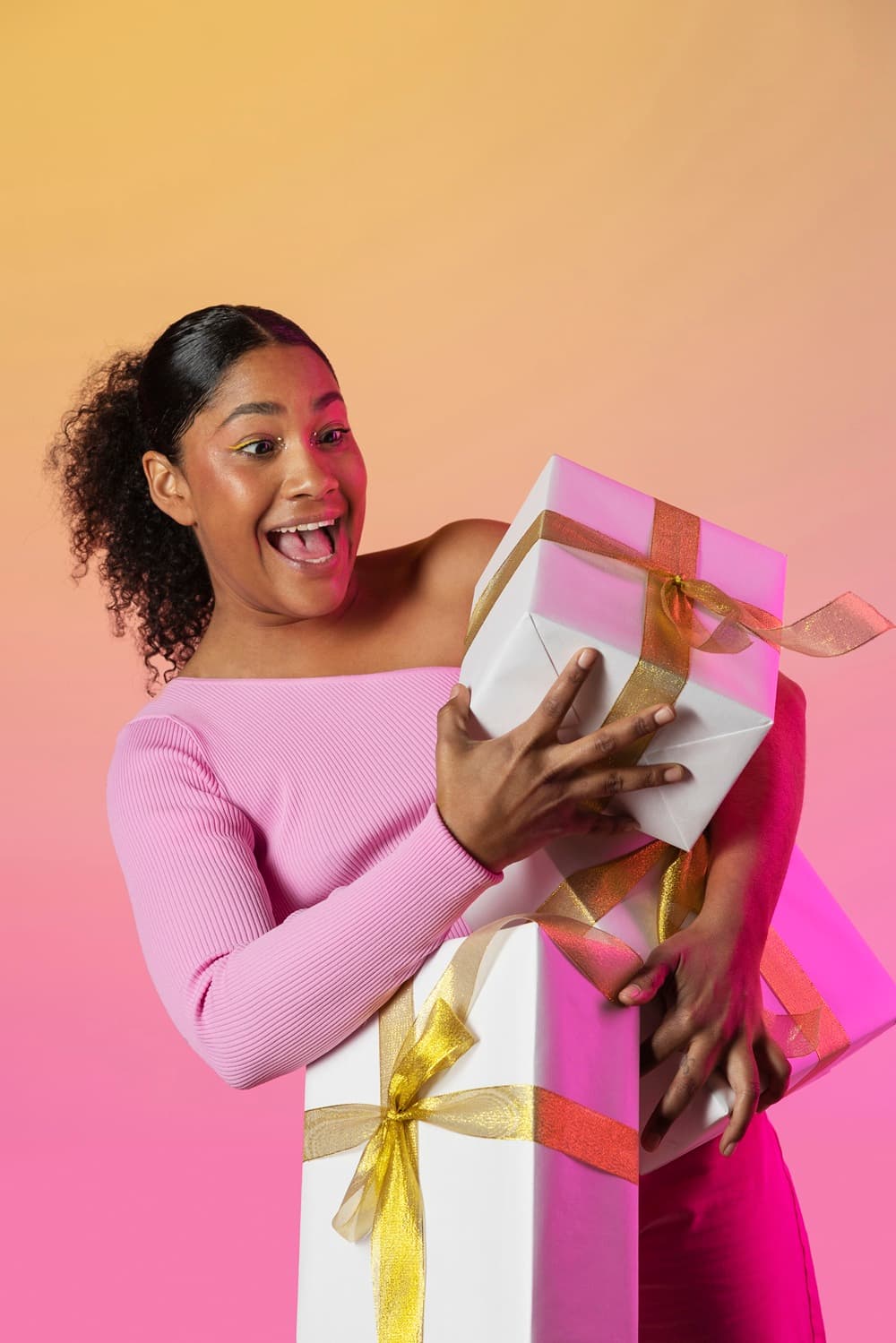 A delighted recipient hugging a stack of gift boxes
