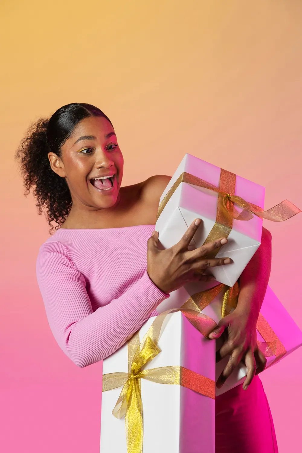 A delighted recipient hugging a stack of gift boxes